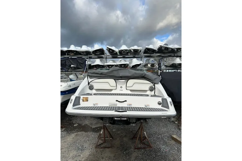 Slide: The Image of 2016 Yamaha Boats 212SS in storage, rear view under cloudy sky. - 9