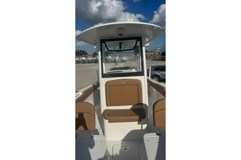 Slide: The Image of 2022 Sea Hunt Gamefish 25 boat interior with brown seating under a blue sky. - 10
