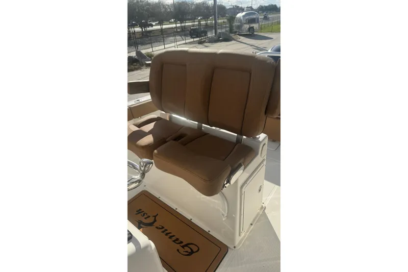 Slide: The Image of 2022 Sea Hunt Gamefish 25 boat with brown cushioned seating and deck mat. - 17