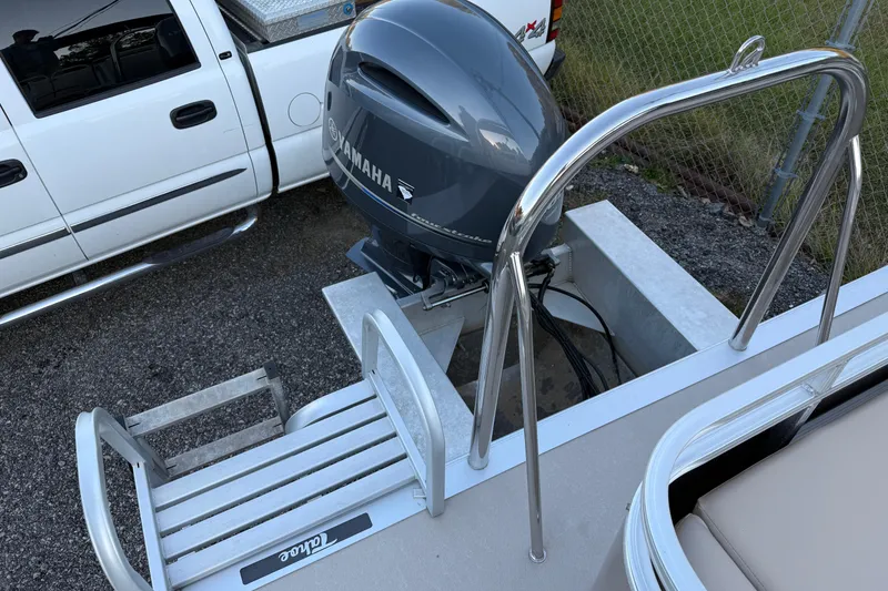 Slide: The Image of 2011 Tahoe Pontoon 2485 DRL with Yamaha outboard motor and ladder, parked beside a white truck. - 9