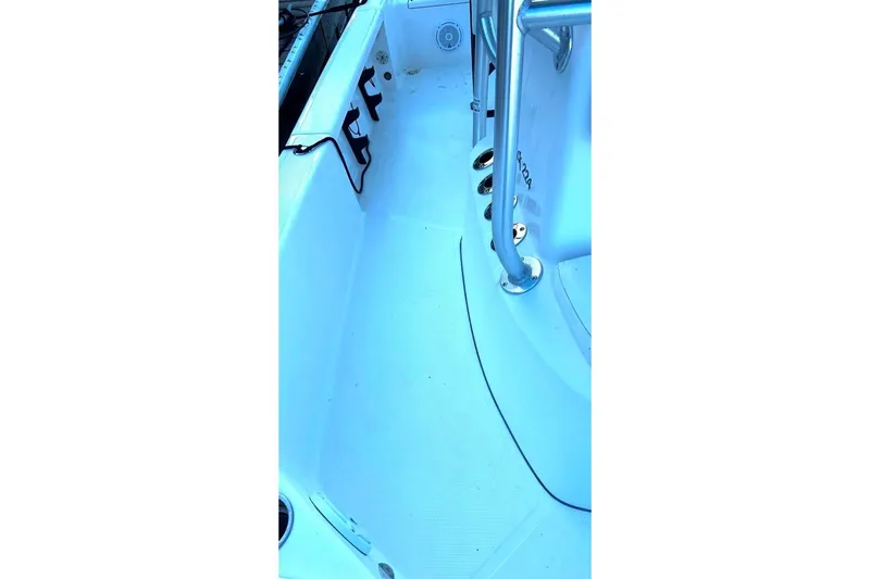 Slide: The Image of Interior of a 2015 BlackJack 224 boat, featuring clean deck and metal railings. - 12
