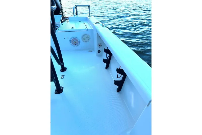 Slide: The Image of 2015 BlackJack 224 boat interior with rod holders, near calm water. - 13