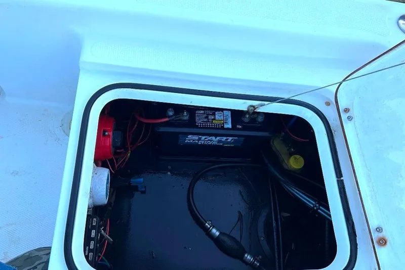 Slide: The Image of Open hatch of a 2015 BlackJack 224 boat showing battery and wiring. - 19