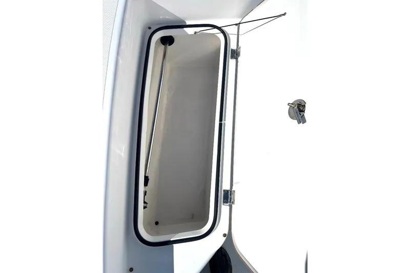 Slide: The Image of Open storage compartment on a 2015 BlackJack 224 boat, featuring a sleek white interior. - 24