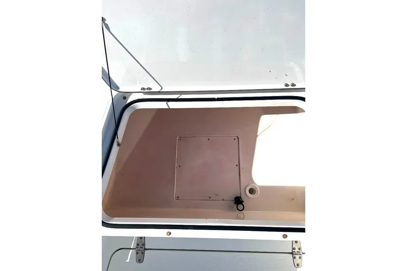 Slide: The Image of Open storage compartment on a 2015 BlackJack 224 boat, featuring a clean interior. - 26