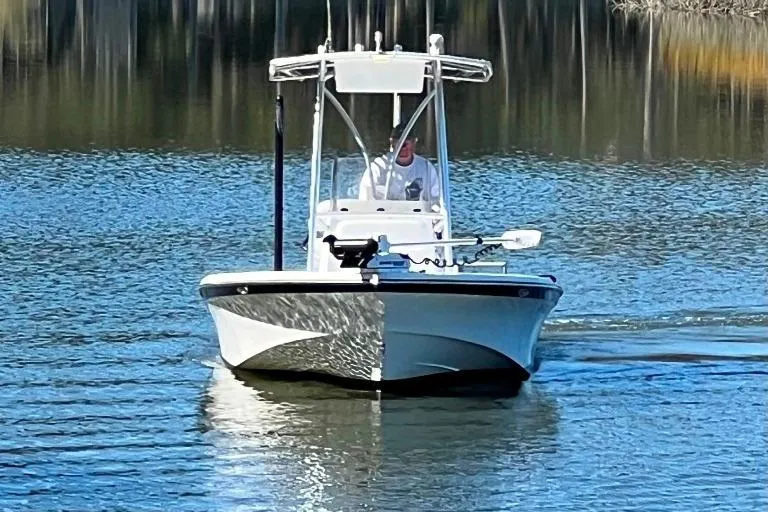 Slide: The Image of A 2015 BlackJack 224 boat cruising on calm water with a person at the helm. - 3