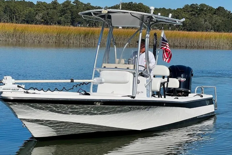 Slide: The Image of A 2015 BlackJack 224 boat on calm water with an American flag. - 4