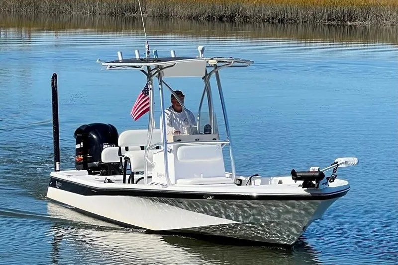 Slide: The Image of A 2015 BlackJack 224 boat with an American flag on calm water. - 5