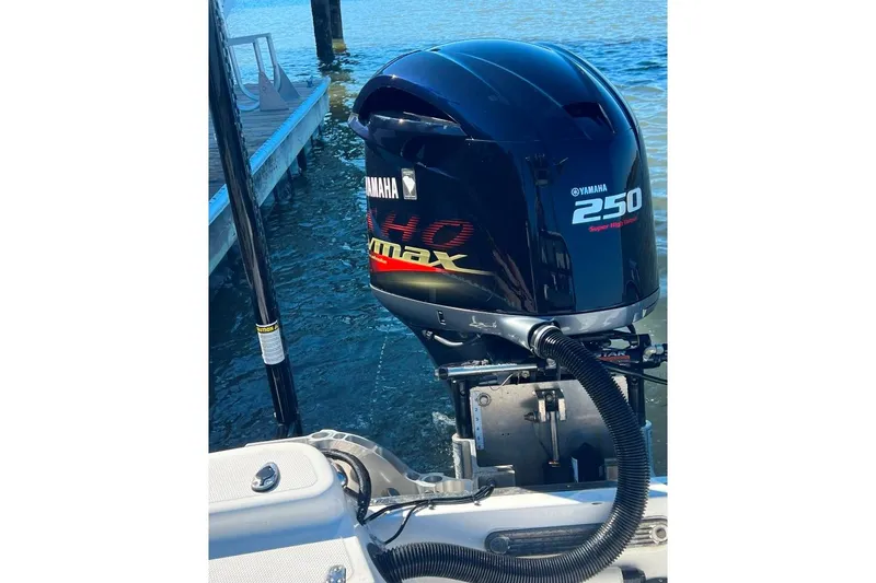 Slide: The Image of Yamaha 250 outboard motor on BlackJack 224 boat, docked by the water. - 7