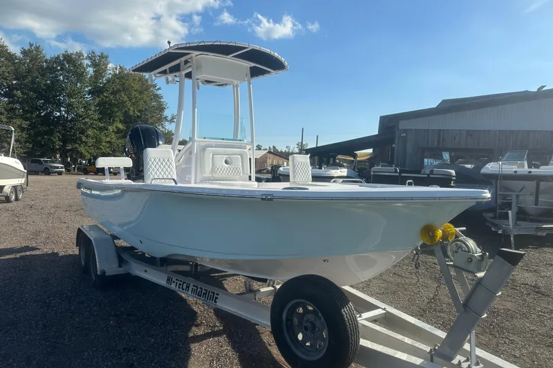 Slide: The Image of 2026 Action Craft 22 Bay boat on trailer, parked outdoors under a clear sky. - 10