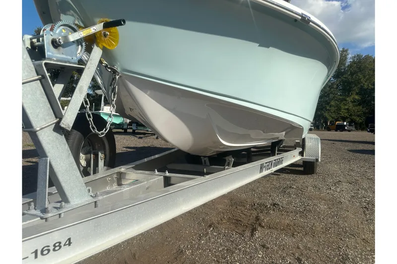 Slide: The Image of 2026 Action Craft 22 Bay boat on trailer, parked outdoors under a clear sky. - 12