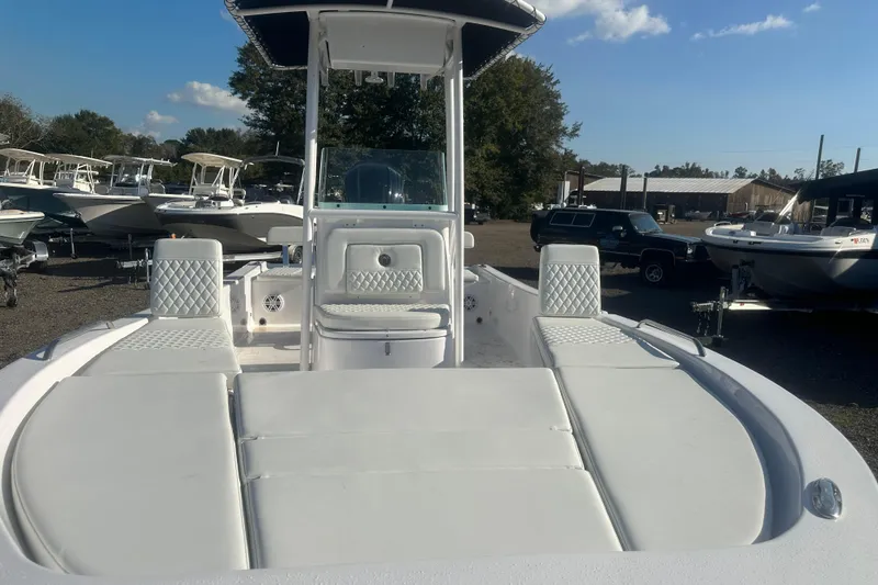 Slide: The Image of 2026 Action Craft 22 Bay boat with cushioned seating, parked in a marina under clear skies. - 14