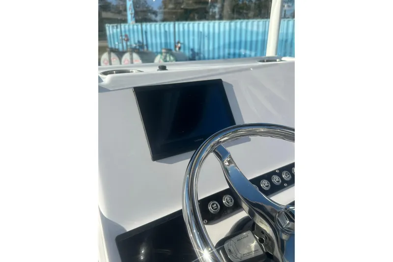 Slide: The Image of 2026 Action Craft 22 Bay boat dashboard with steering wheel and display screen. - 19