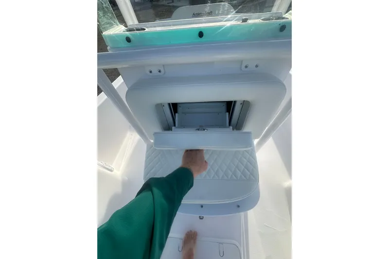 Slide: The Image of 2026 Action Craft 22 Bay boat interior with storage compartment and hand reaching in. - 32