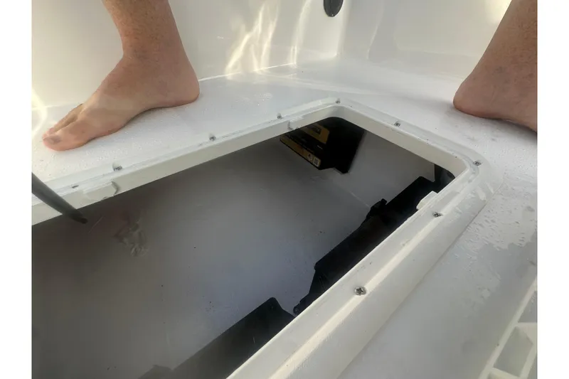Slide: The Image of Open hatch on 2026 Action Craft 22 Bay boat deck with visible feet. - 35
