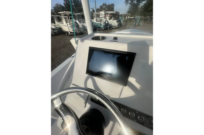 Slide: The Image of 2026 Action Craft 22 Bay boat dashboard with steering wheel and display screen. - 52