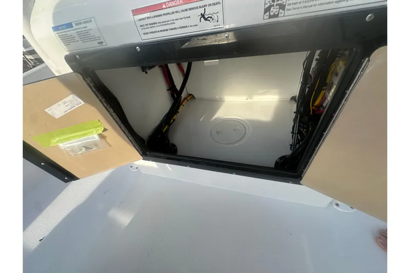 Slide: The Image of Open storage compartment on 2026 Action Craft 22 Bay boat, showing interior wiring and components. - 58