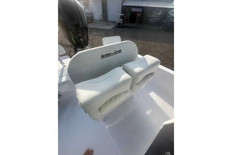 Slide: The Image of 2026 Action Craft 22 Bay boat with white cushioned seating and motor in a sunny outdoor setting. - 60