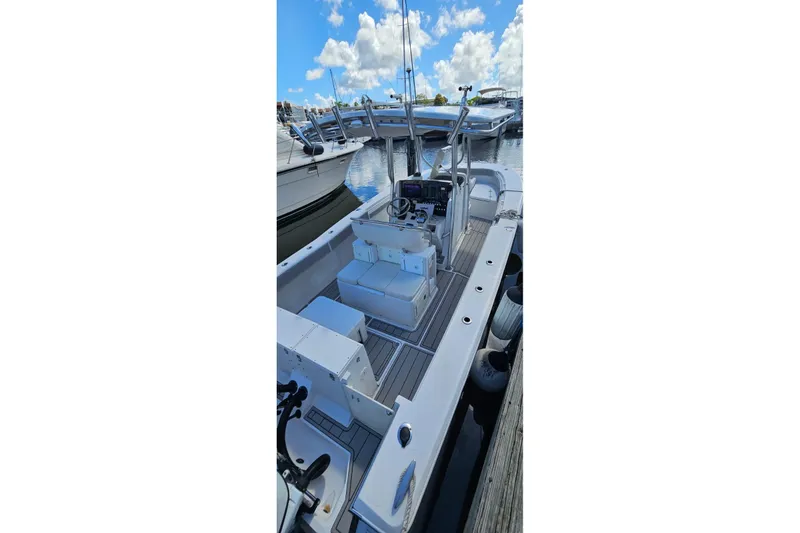 Slide: The Image of 2007 Southport 26 Center Console boat docked, showcasing spacious deck and modern controls. - 11