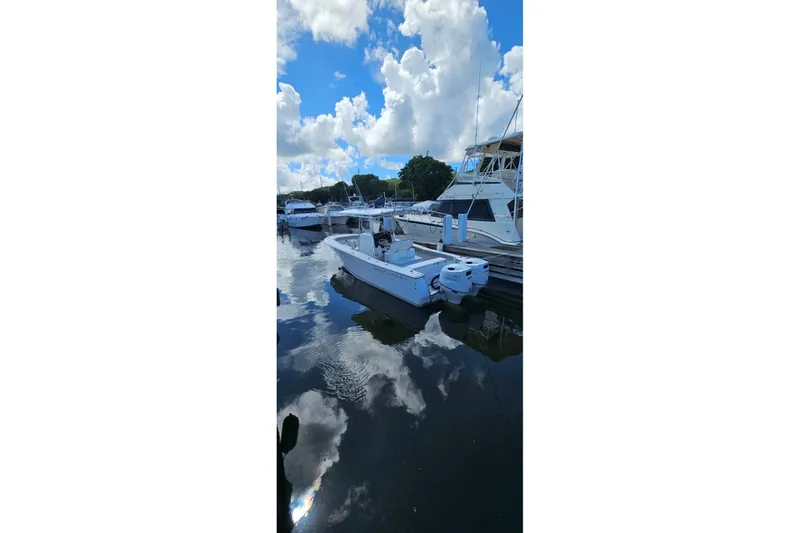 Slide: The Image of 2007 Southport 26 Center Console boat docked in a marina under a blue sky. - 13