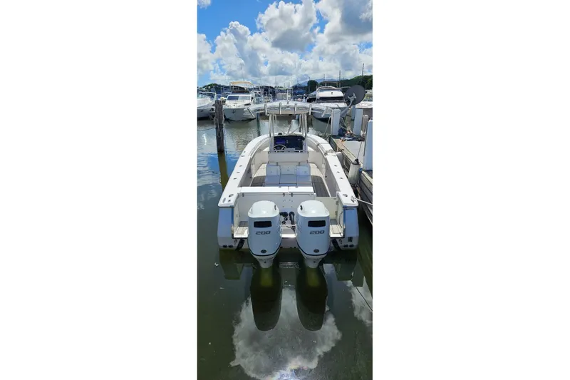 Slide: The Image of 2007 Southport 26 Center Console boat docked with twin engines, under a blue sky. - 14