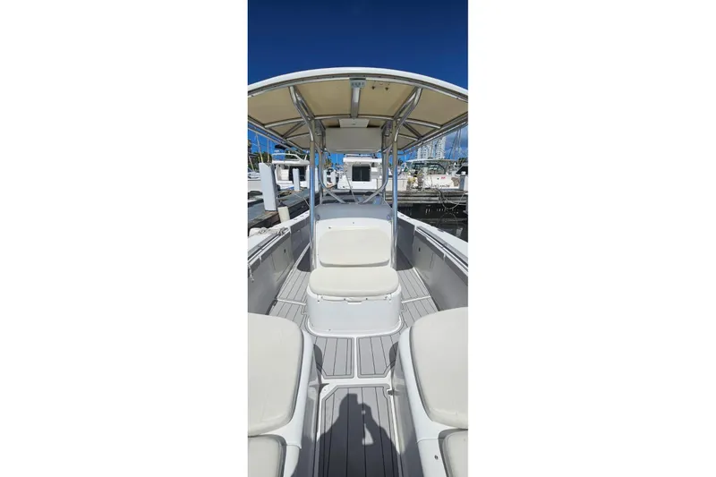 Slide: The Image of 2007 Southport 26 Center Console boat interior with seating and canopy, docked at marina. - 6