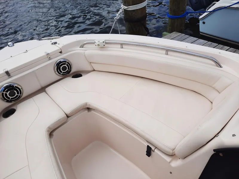 Slide: The Image of 2016 Grady-White Freedom 205 boat interior with beige seating and speakers by the water. - 22