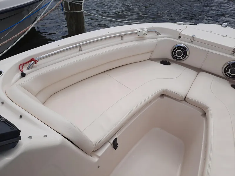 Slide: The Image of 2016 Grady-White Freedom 205 boat interior with white cushioned seating and speakers. - 23
