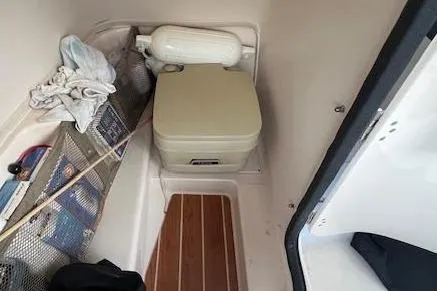 Slide: The Image of 2016 Grady-White Freedom 205 boat interior with portable toilet and storage area. - 29