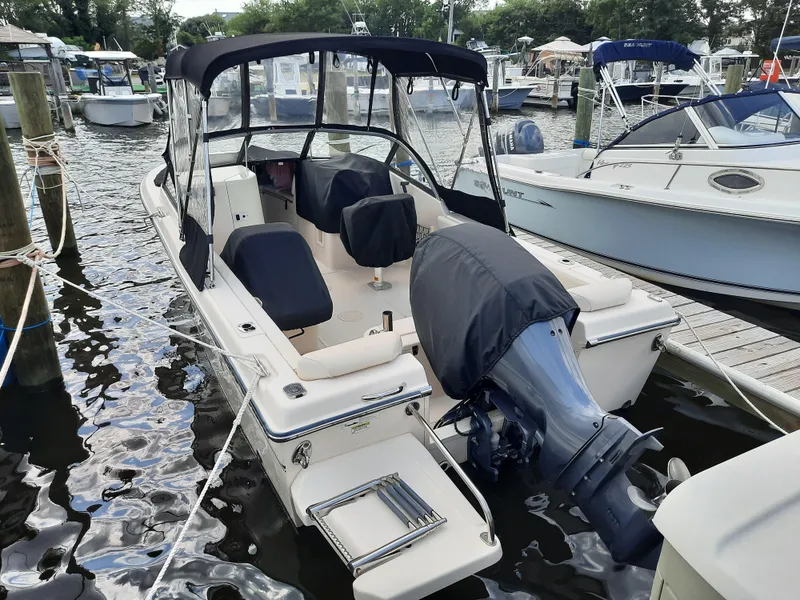 Slide: The Image of 2016 Grady-White Freedom 205 boat docked at marina, featuring covered seats and motor. - 5