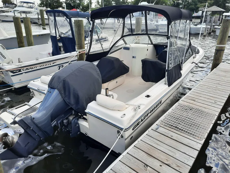 Slide: The Image of 2016 Grady-White Freedom 205 boat docked, featuring covered seating and outboard motor. - 6