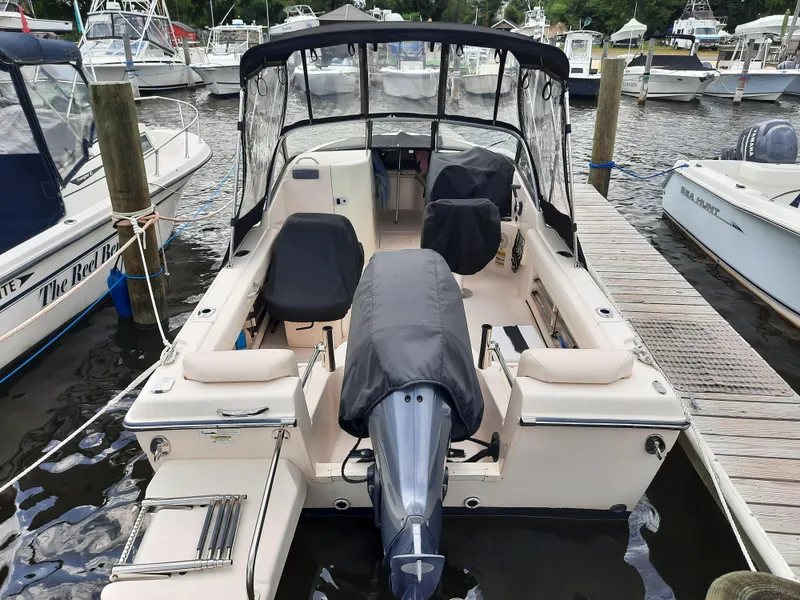 Slide: The Image of 2016 Grady-White Freedom 205 boat docked at marina, featuring covered seating and motor. - 7