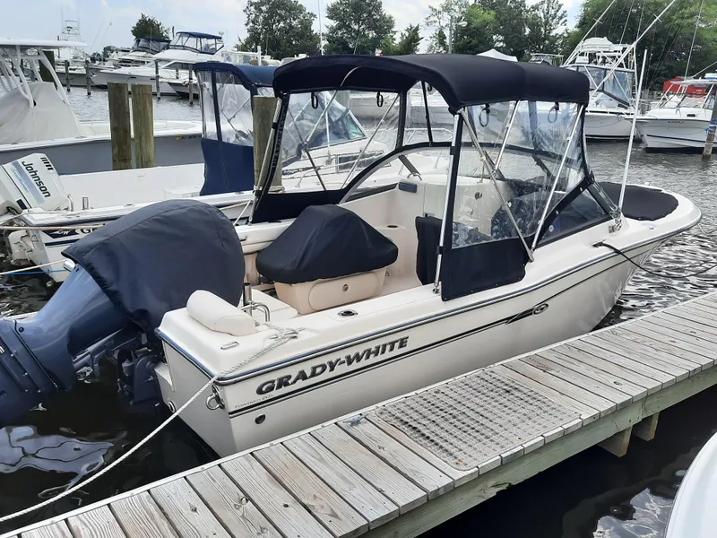 Slide: The Image of 2016 Grady-White Freedom 205 boat docked at marina, featuring a covered seating area. - 9