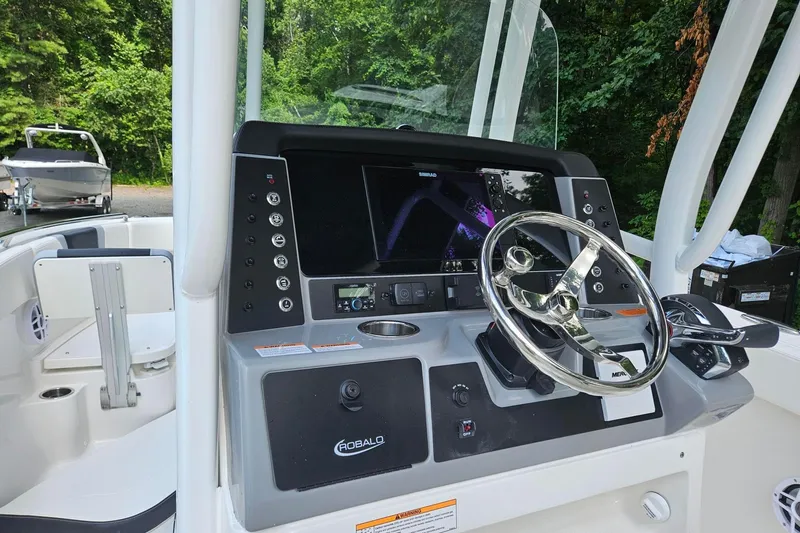 Slide: The Image of 2025 Robalo R230 Center Console boat dashboard with steering wheel and control panel. - 13