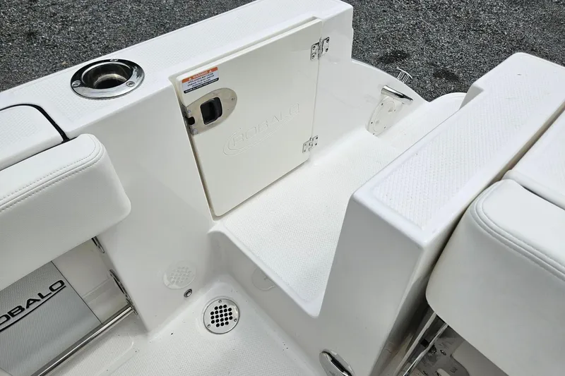 Slide: The Image of 2025 Robalo R230 Center Console boat interior with white seating and storage compartment. - 21