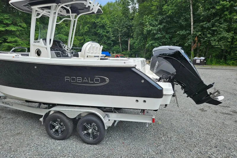 Slide: The Image of 2025 Robalo R230 Center Console boat on trailer, featuring sleek design and powerful outboard motor. - 3