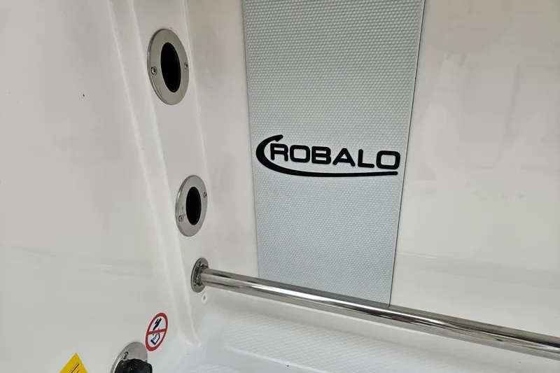 Slide: The Image of 2025 Robalo R230 Center Console interior detail with logo and stainless steel fittings. - 33