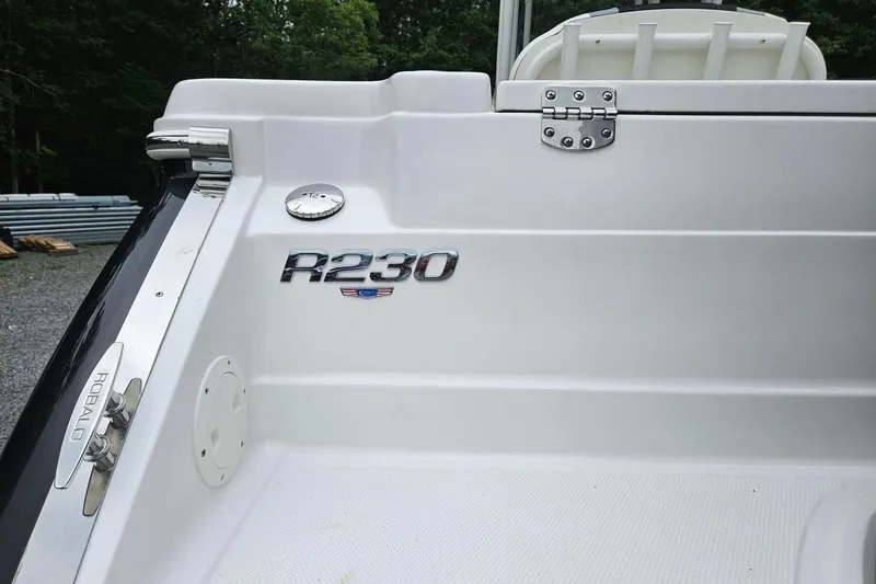Slide: The Image of 2025 Robalo R230 Center Console boat, white interior with logo and hardware details. - 38