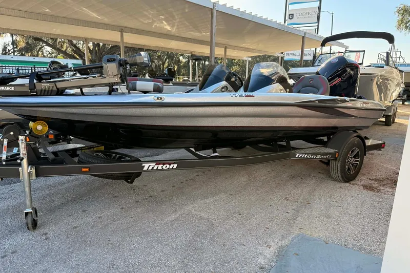 The Image of 2026 Triton 179 TrX boat on trailer, displayed outdoors under a canopy. - 1