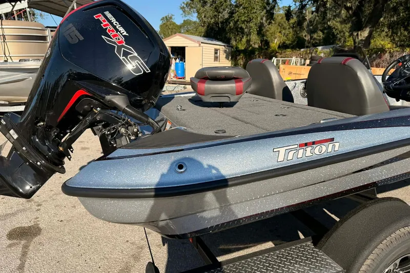 Slide: The Image of 2026 Triton 179 TrX fishing boat on trailer, parked outdoors. - 2