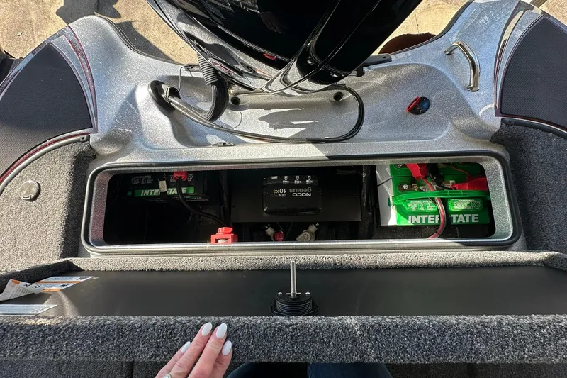 Slide: The Image of 2026 Triton 179 TrX boat battery compartment with Interstate batteries and NOCO Genius charger. - 25