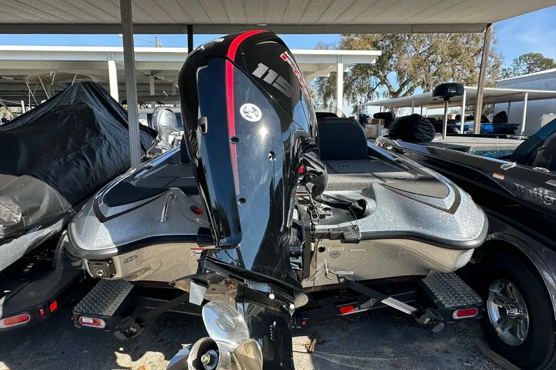 Slide: The Image of 2026 Triton 179 TrX boat with powerful outboard motor, parked under a canopy. - 29