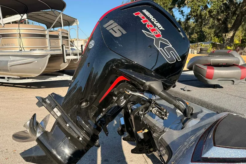 Slide: The Image of 2026 Triton 179 TrX with Mercury Pro XS outboard motor, parked near pontoon boats. - 32