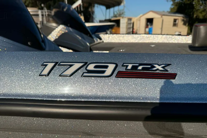 Slide: The Image of 2026 Triton 179 TrX boat on trailer, silver finish, parked outdoors. - 4