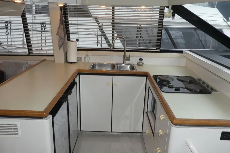 Slide: The Image of 1994 Bayliner 4388 Motor Yacht kitchen with sink, stove, and ample counter space. - 15