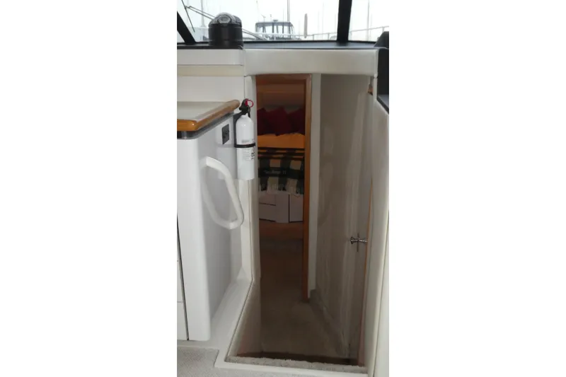 Slide: The Image of 1994 Bayliner 4388 Motor Yacht interior with open cabin door and fire extinguisher. - 18