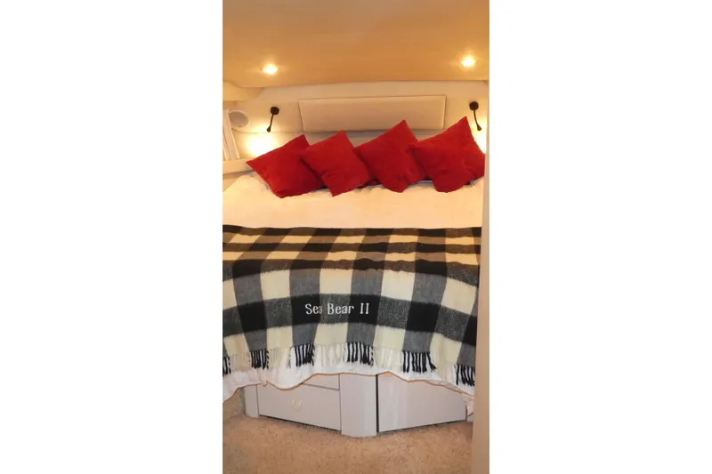Slide: The Image of Cozy bedroom in 1994 Bayliner 4388 Motor Yacht with red pillows and plaid blanket. - 19