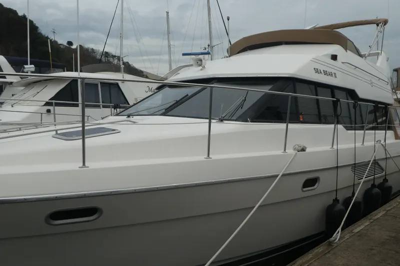 Slide: The Image of 1994 Bayliner 4388 Motor Yacht docked at marina, side view. - 2