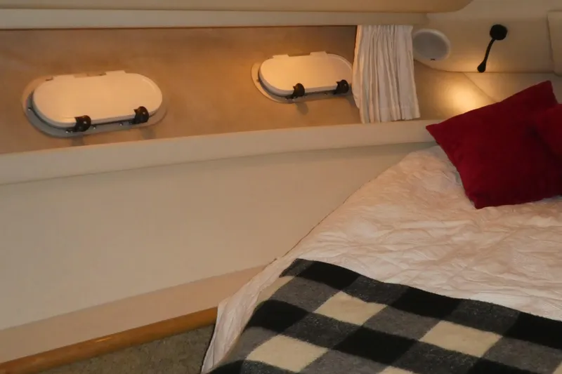 Slide: The Image of Cozy bedroom interior of 1994 Bayliner 4388 Motor Yacht with portholes and bedding. - 22