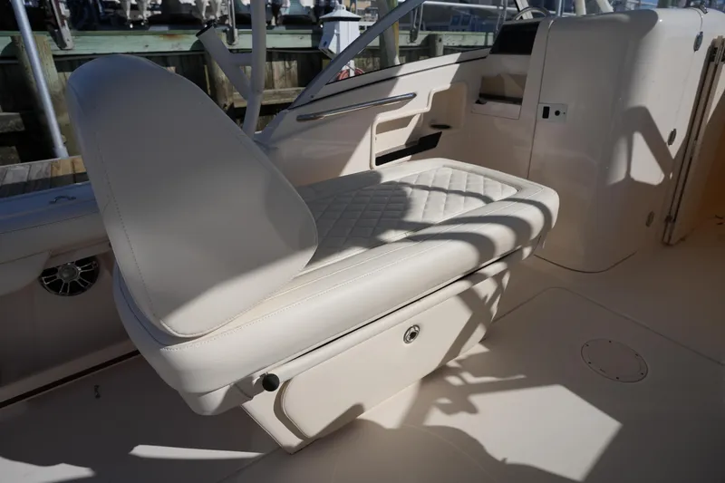 Slide: The Image of 2022 Grady-White Freedom 235 boat interior with cushioned seating and storage. - 17